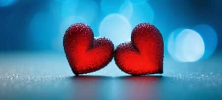 A computer generated image of two red hearts set on a blue background.