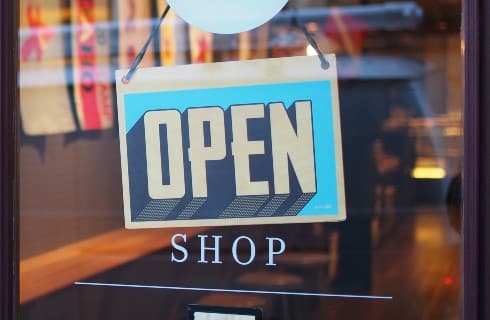 Store window with a blue and white open sign