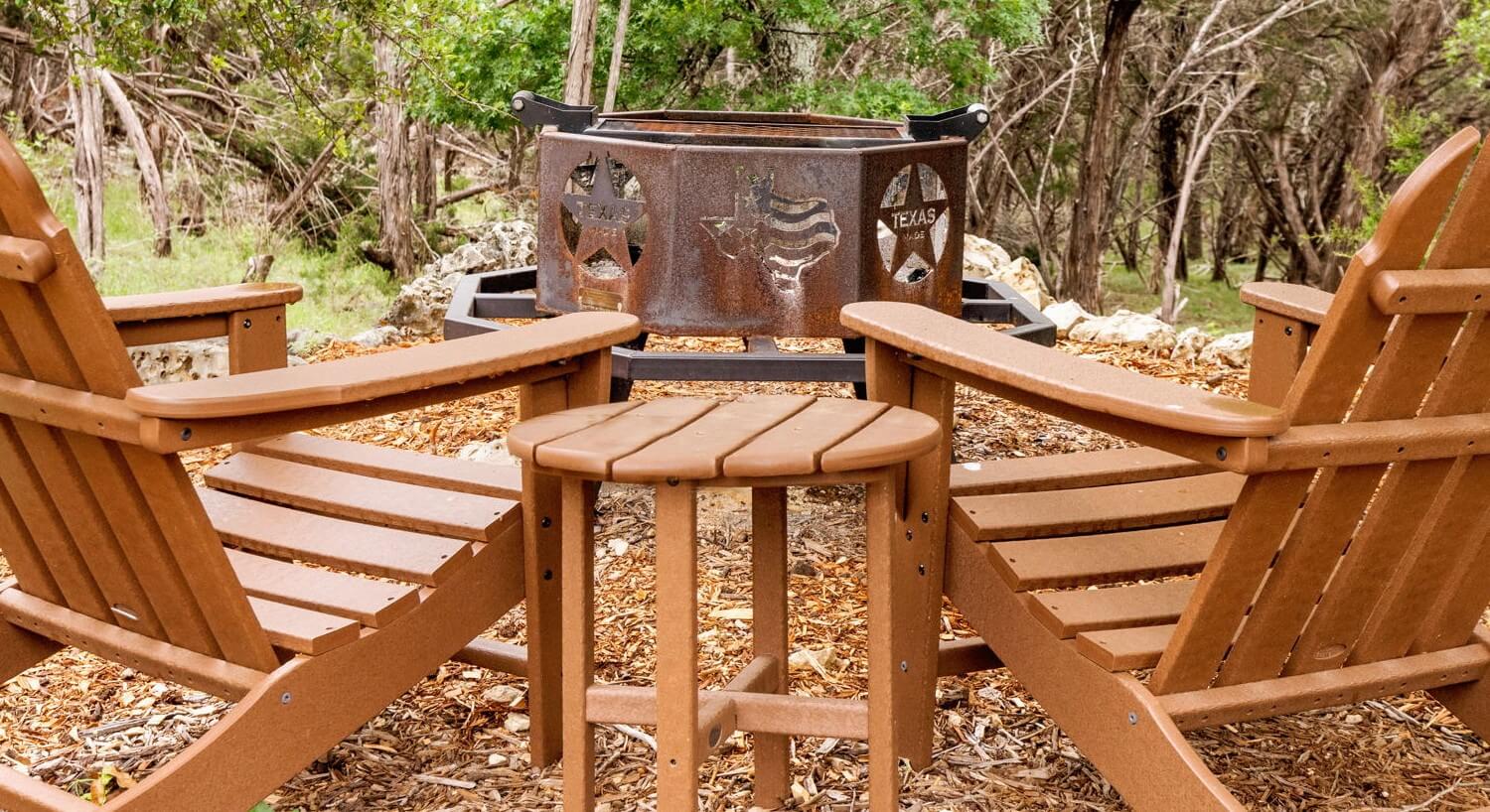 Fire pit with two chairs in the woods.