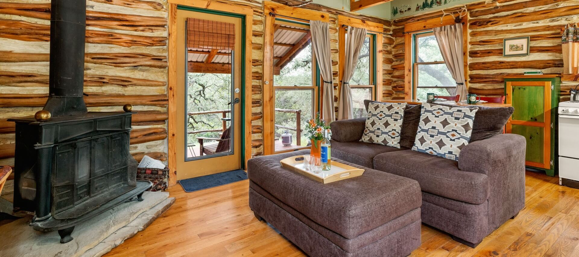 Small cabin with a front porch and side area with grill and hot tub