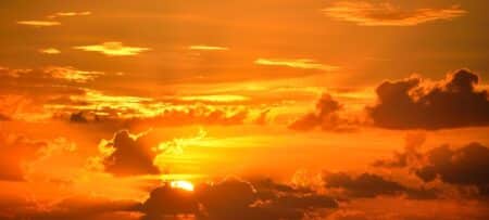 An image of a bright orange sunrise with clouds.